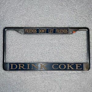 License Plate Frame,chrome, “Friends Don’t Let Friends Drink Coke”. Used